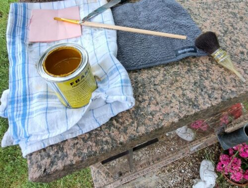 Dorure à la feuille d'or sur une porte de colombarium ornée d'une gravure de 1994