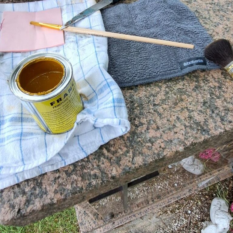 Dorure à la feuille d'or sur une porte de colombarium ornée d'une gravure de 1994